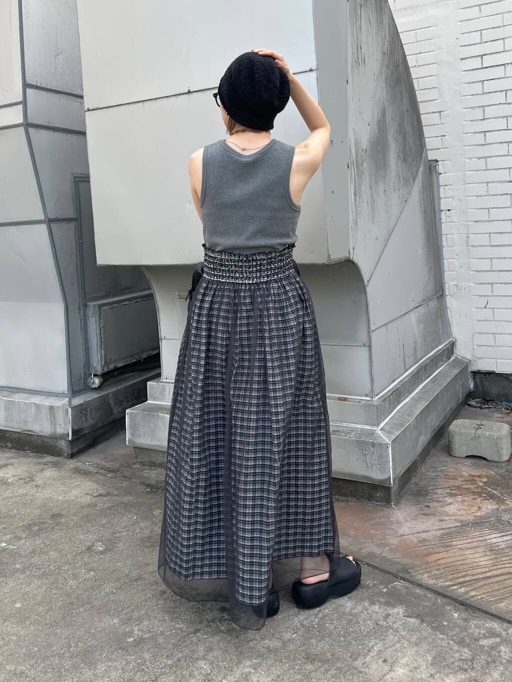 グレー系のタンクトップ、ブラック系のスカート、ブラック系のボストンバッグを着用したレディースの夏コーディネートの2枚目の写真