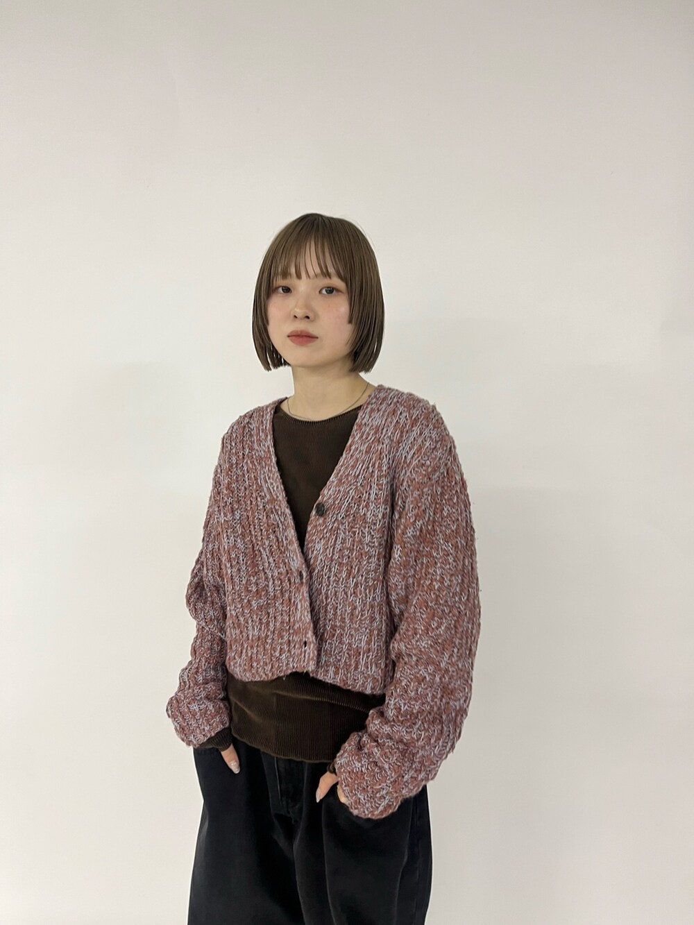 ブラック系のデニムパンツ、ブラウン系のスニーカー、ブラウン系のニット/セーターを着用したレディースの秋コーディネートの2枚目の写真