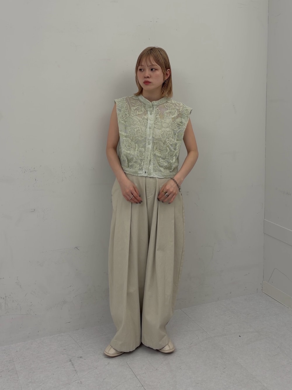 ホワイト系のその他パンツ、グリーン系のシャツ/ブラウス、ホワイト系のパンプスを着用したレディースの春コーディネートの3枚目の写真