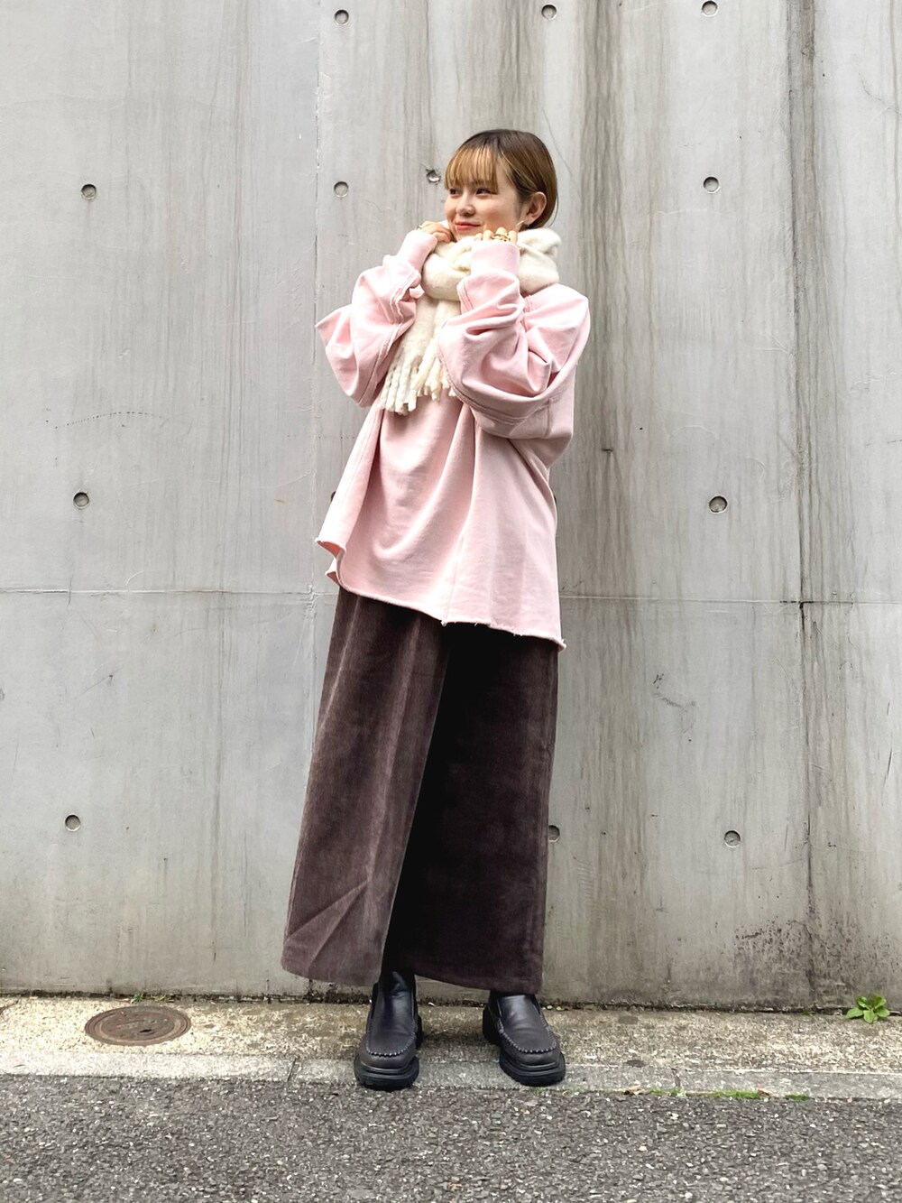 グレー系のブーツ、ブラウン系のワンピース、ベージュ系のスウェットを着用したレディースの冬コーディネートの4枚目の写真