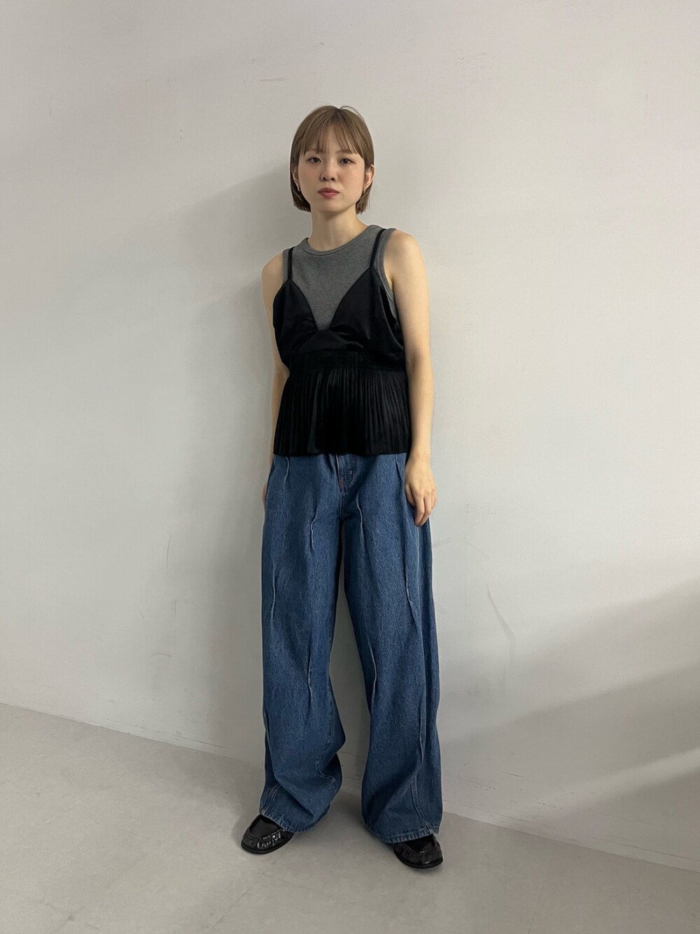 ブルー系のデニムパンツ、ブラック系のローファー、ブラック系のワンピースを着用したレディースの夏コーディネートの4枚目の写真