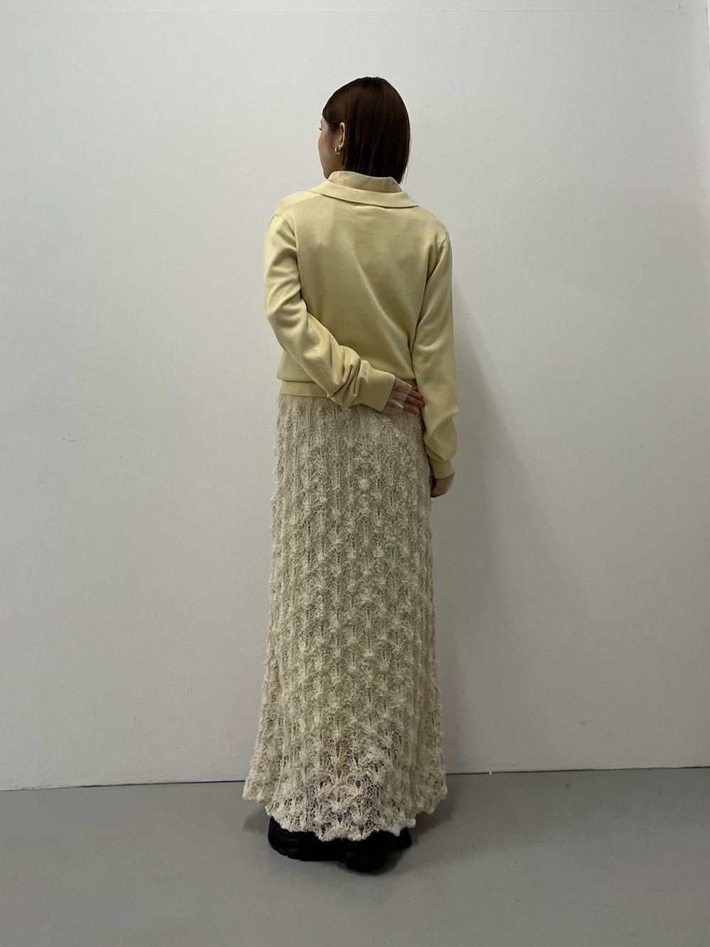 ホワイト系のニット/セーター、ブラック系のスニーカーを着用したレディースの秋コーディネートの4枚目の写真