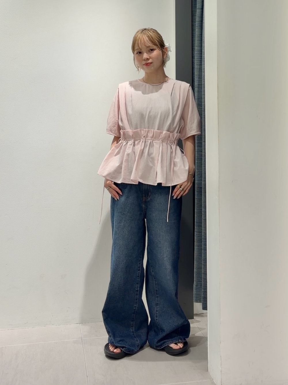 ブルー系のデニムパンツ、ブラック系のサンダル、ピンク系のシャツ/ブラウスを着用したレディースの夏コーディネートの4枚目の写真
