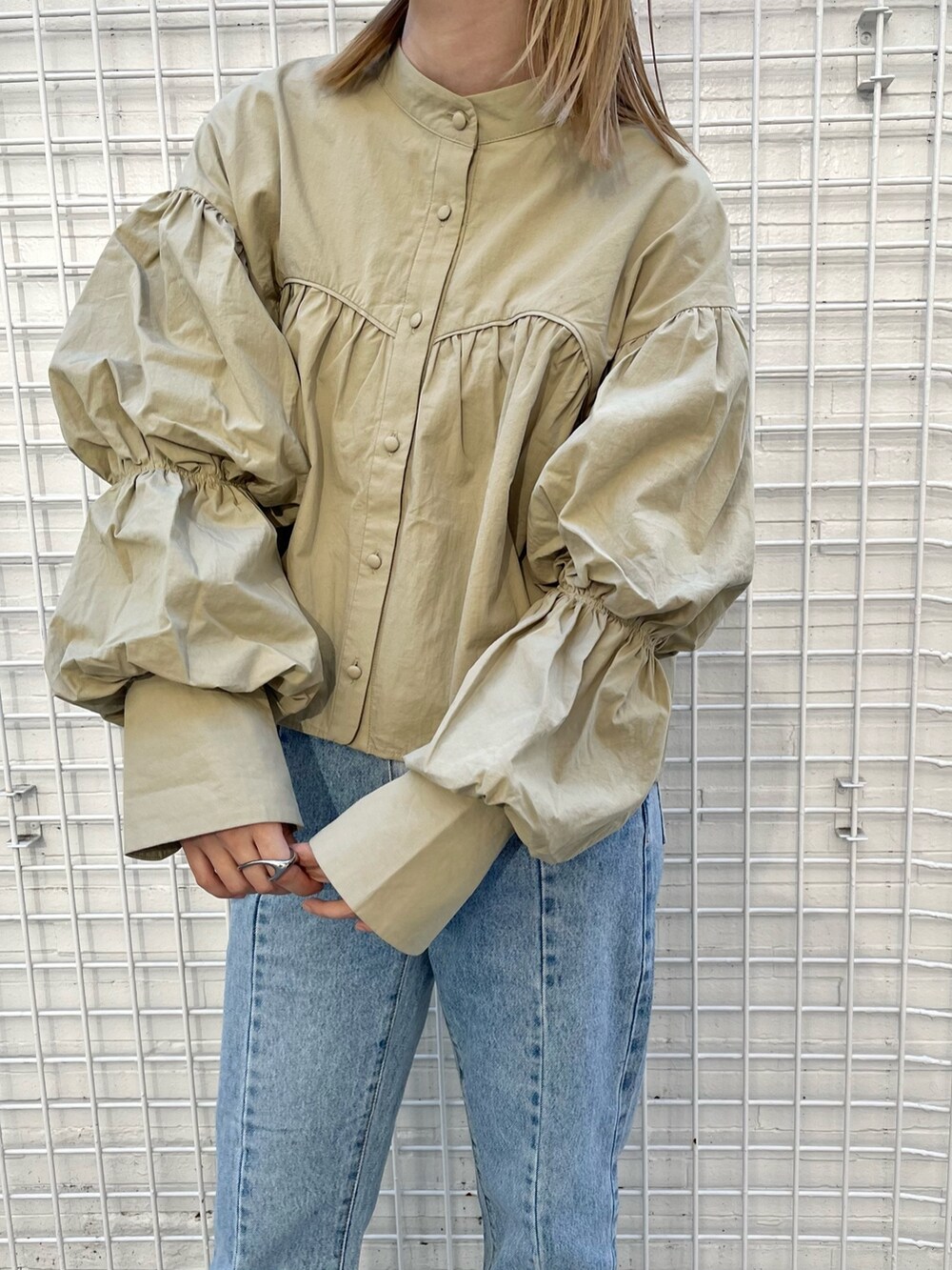 ブルー系のデニムパンツ、ブラウン系のその他シューズ、ベージュ系のシャツ/ブラウスを着用したレディースの秋コーディネートの2枚目の写真