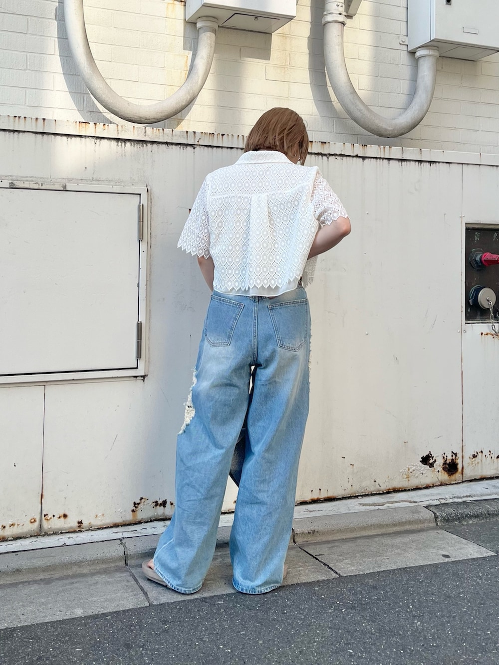 ブルー系のデニムパンツ、シルバー系のトートバッグ、ホワイト系のシャツ/ブラウスを着用したレディースの夏コーディネートの4枚目の写真