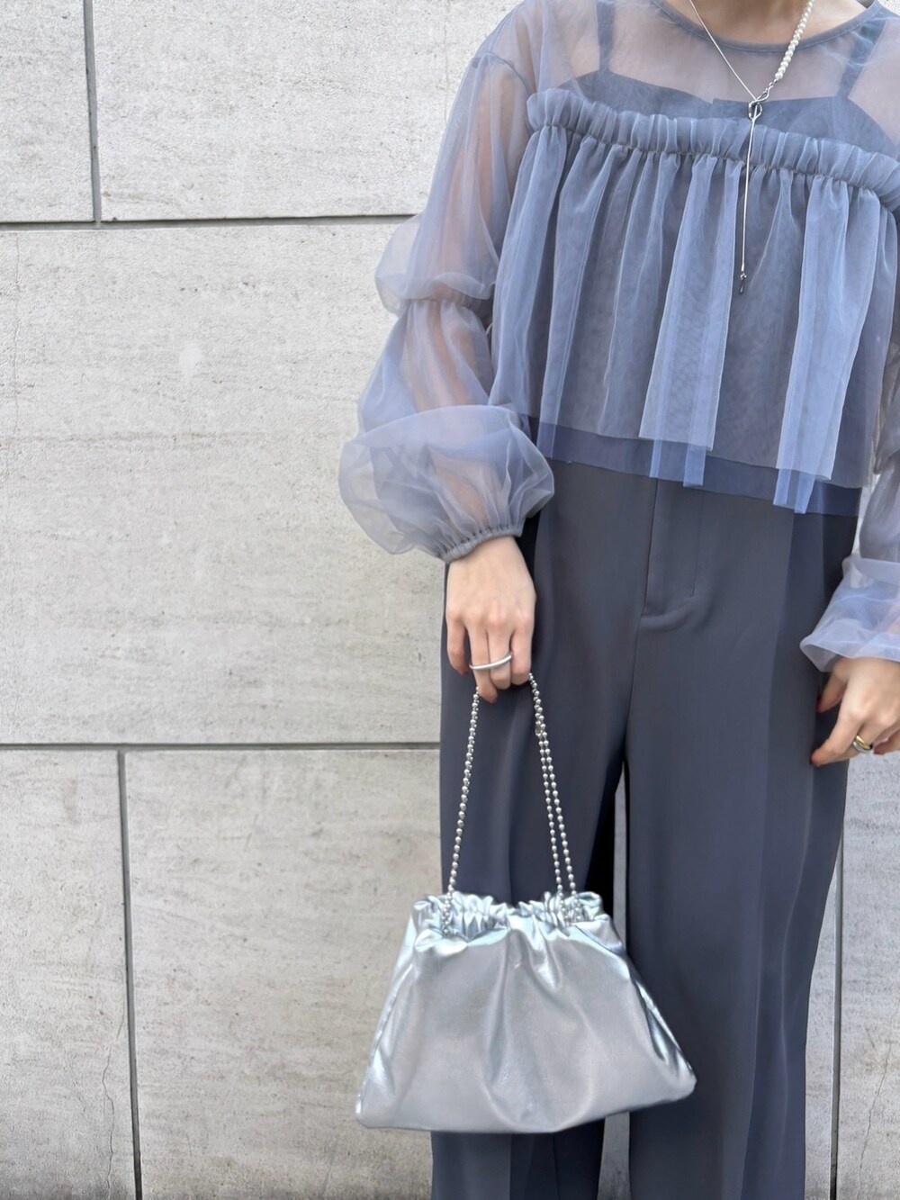 シルバー系のハンドバッグ、シルバー系のパンプス、グレー系のサロペット/オーバーオールを着用したレディースの冬コーディネートの4枚目の写真