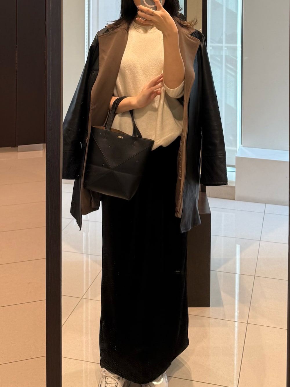 ブラック系のテーラードジャケット、ブラック系のスカート、シルバー系のスニーカーを着用したレディースの冬コーディネートの3枚目の写真