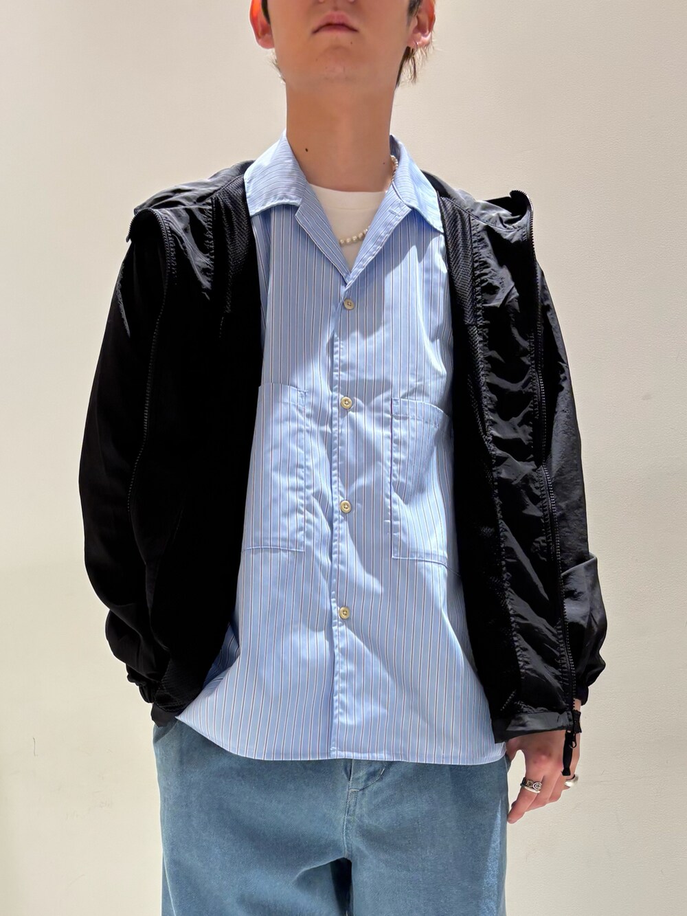 ブルー系のシャツ/ブラウス、ブラック系のマウンテンパーカー、ブルー系のデニムパンツを着用したメンズの春コーディネートの2枚目の写真