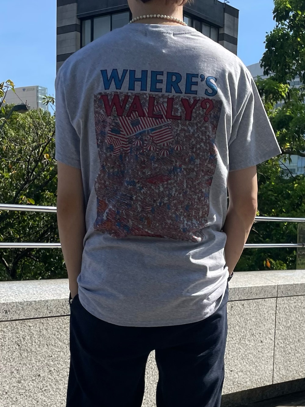 グレー系のTシャツ/カットソー、ブルー系のスラックスを着用したメンズの夏コーディネートの3枚目の写真