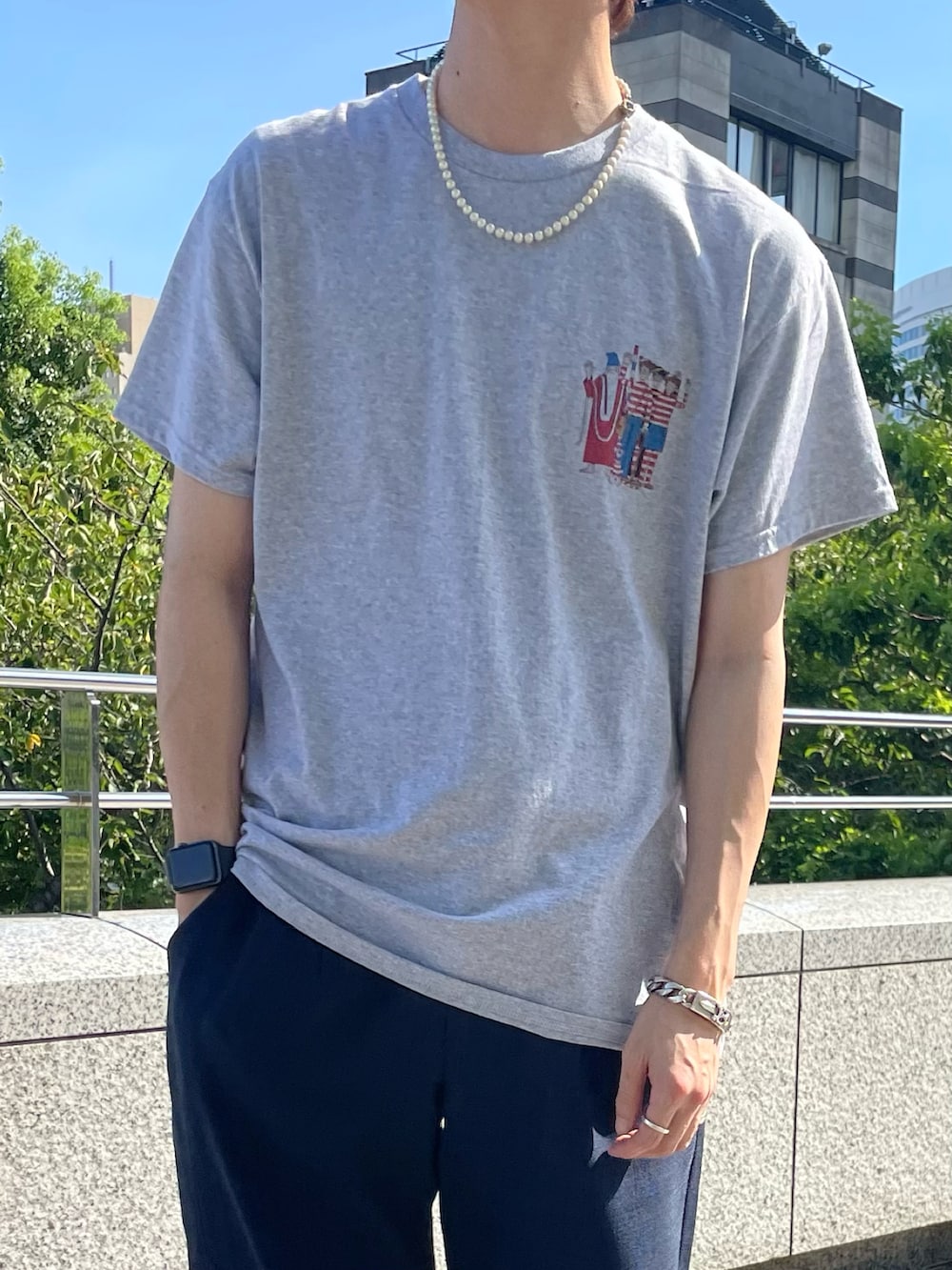 グレー系のTシャツ/カットソー、ブルー系のスラックスを着用したメンズの夏コーディネートの2枚目の写真