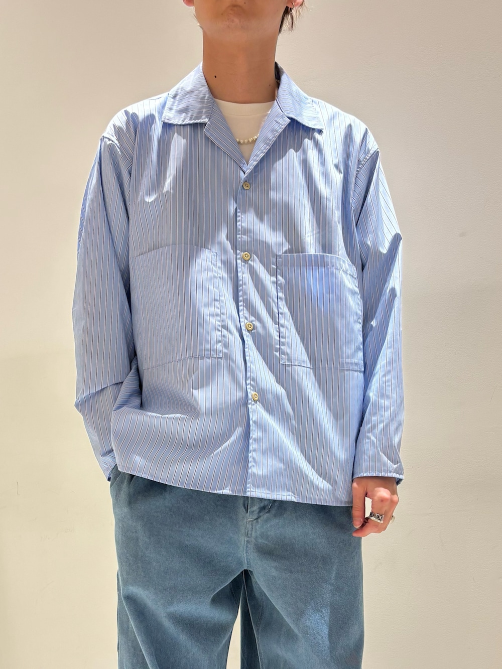 ブルー系のシャツ/ブラウス、ブラック系のマウンテンパーカー、ブルー系のデニムパンツを着用したメンズの春コーディネートの3枚目の写真