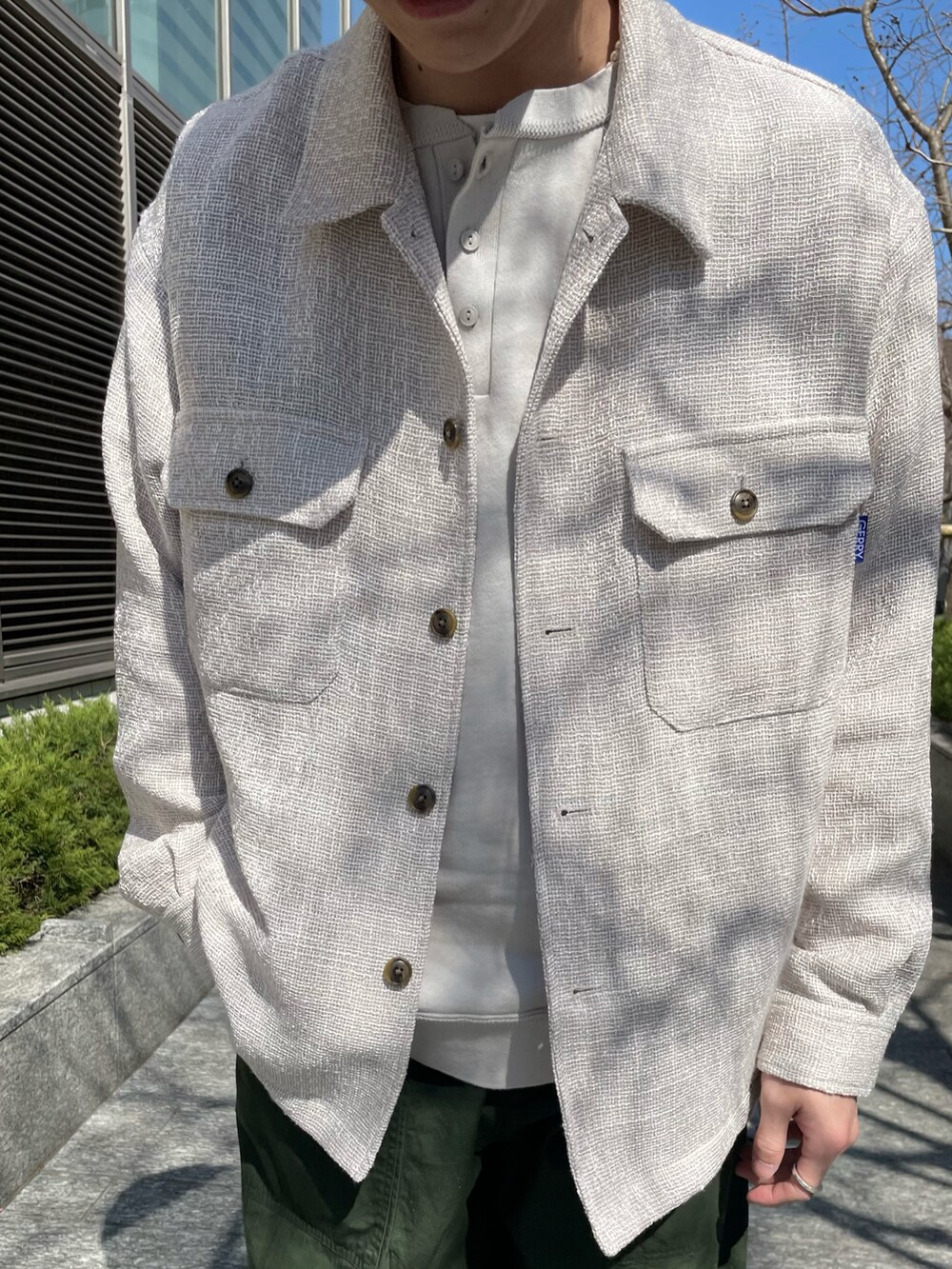 ベージュ系のその他アウター、グリーン系のその他パンツ、ベージュ系のサンダルを着用したメンズの春コーディネートの4枚目の写真