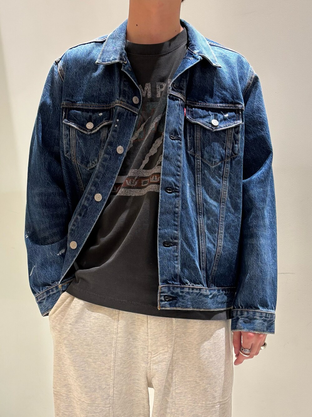 ブルー系のデニムジャケット、ホワイト系のスウェットパンツを着用したメンズの春コーディネートの2枚目の写真