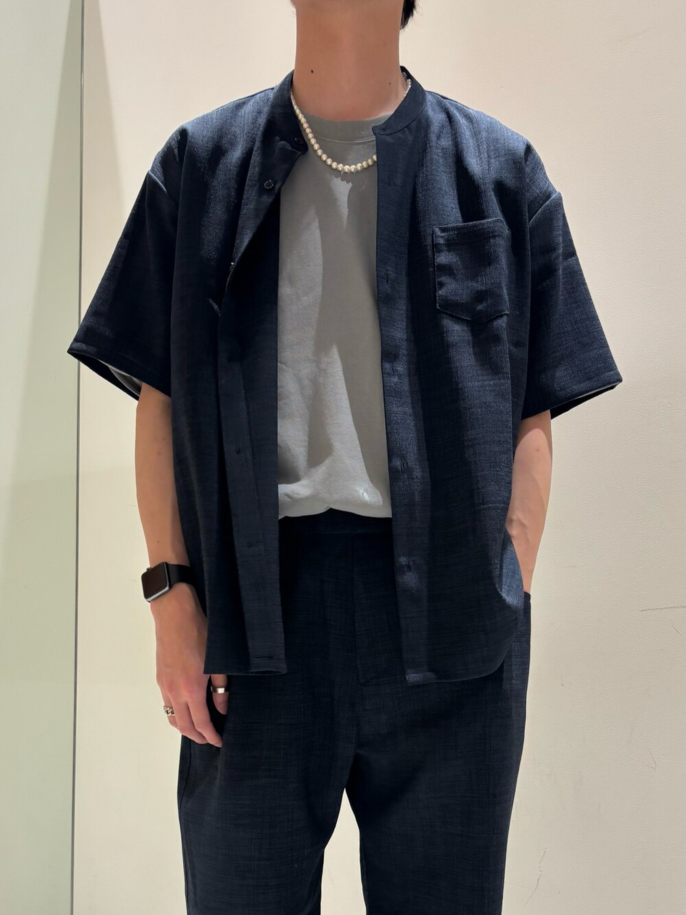 ブルー系のシャツ/ブラウス、グリーン系のTシャツ/カットソー、ブルー系のスラックスを着用したメンズの春コーディネートの2枚目の写真