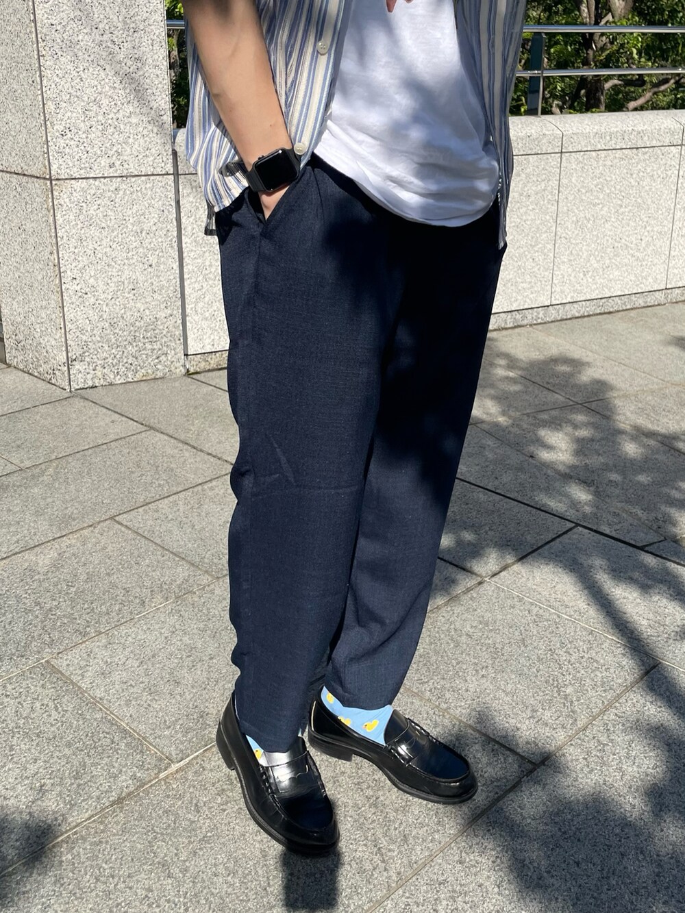 グレー系のTシャツ/カットソー、ブルー系のスラックスを着用したメンズの夏コーディネートの4枚目の写真