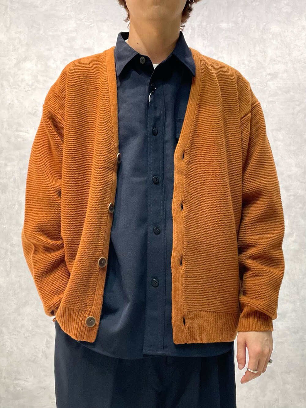 ブラウン系のカーディガン/ボレロ、ブルー系のシャツ/ブラウス、ブルー系のスラックスを着用したメンズの秋コーディネートの2枚目の写真