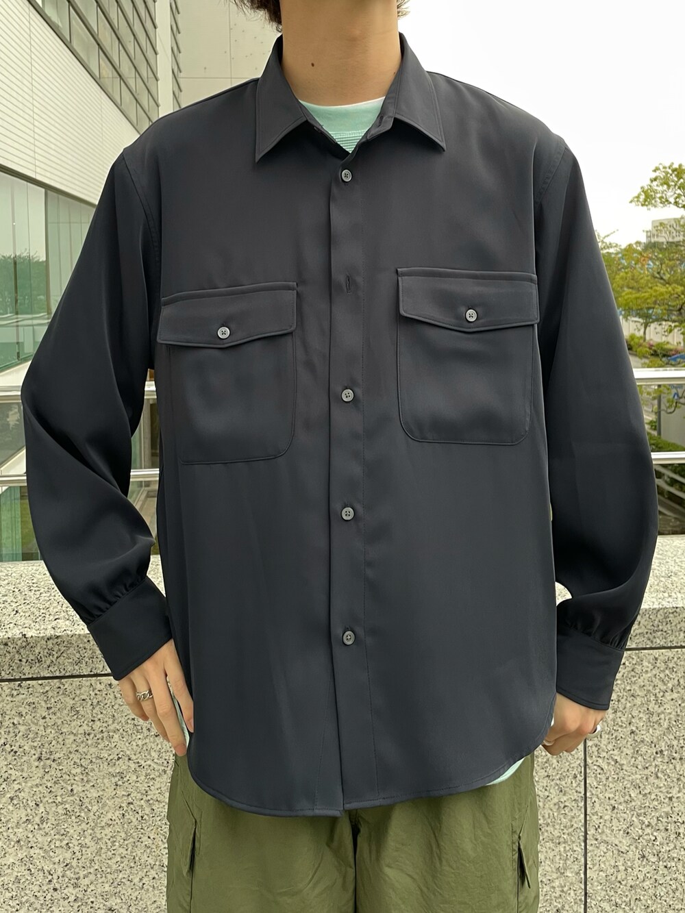 ブルー系のシャツ/ブラウス、グリーン系のカーゴパンツ、グリーン系のTシャツ/カットソーを着用したメンズの春コーディネートの2枚目の写真