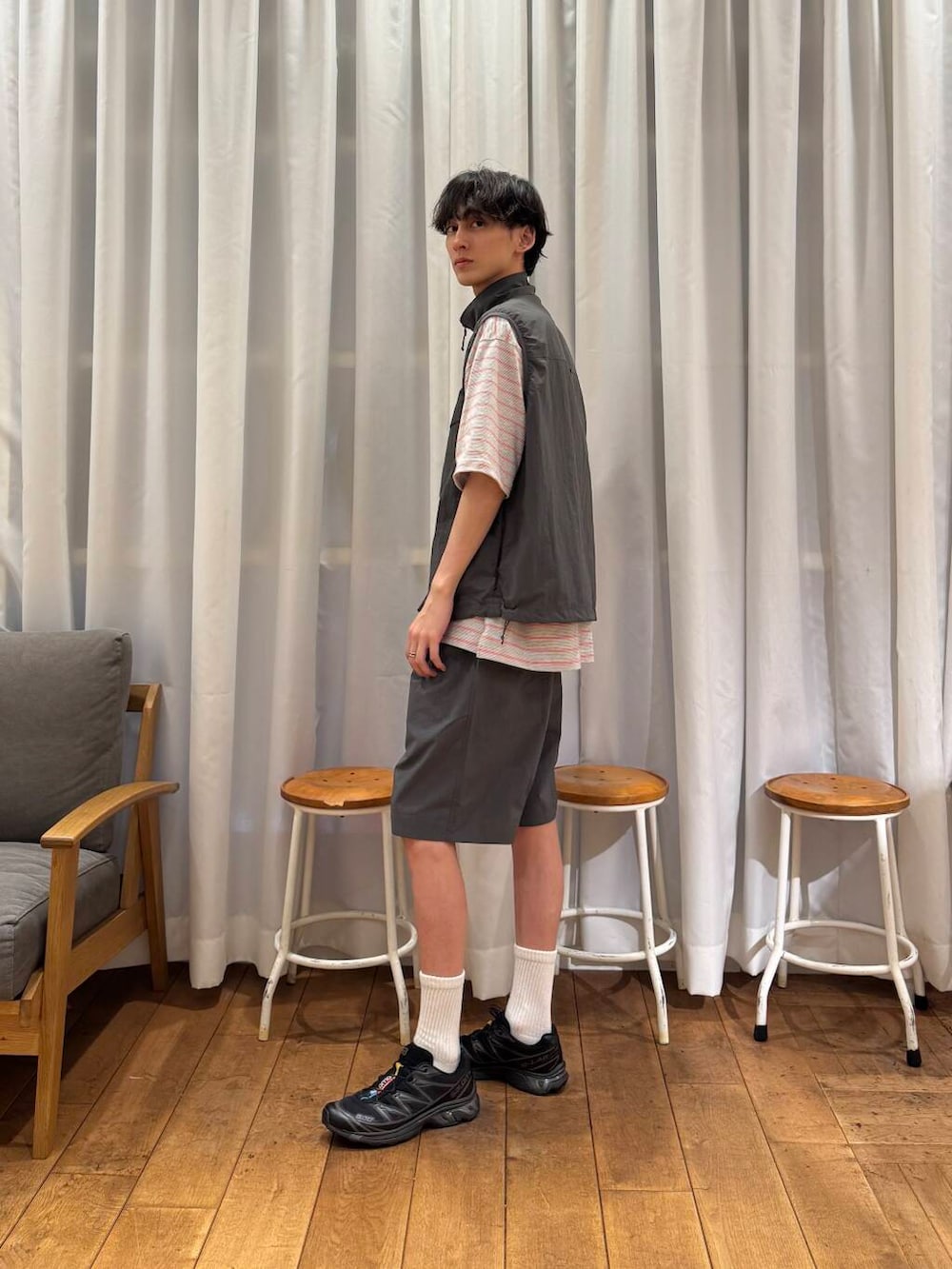 グレー系のベスト、グレー系のその他パンツ、ブラック系のスニーカーを着用したメンズの春コーディネートの2枚目の写真