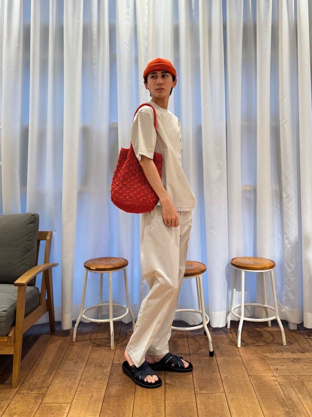 オレンジ系のトートバッグ、グレー系のTシャツ/カットソー、グレー系のその他パンツを着用したメンズの春コーディネートの4枚目の写真