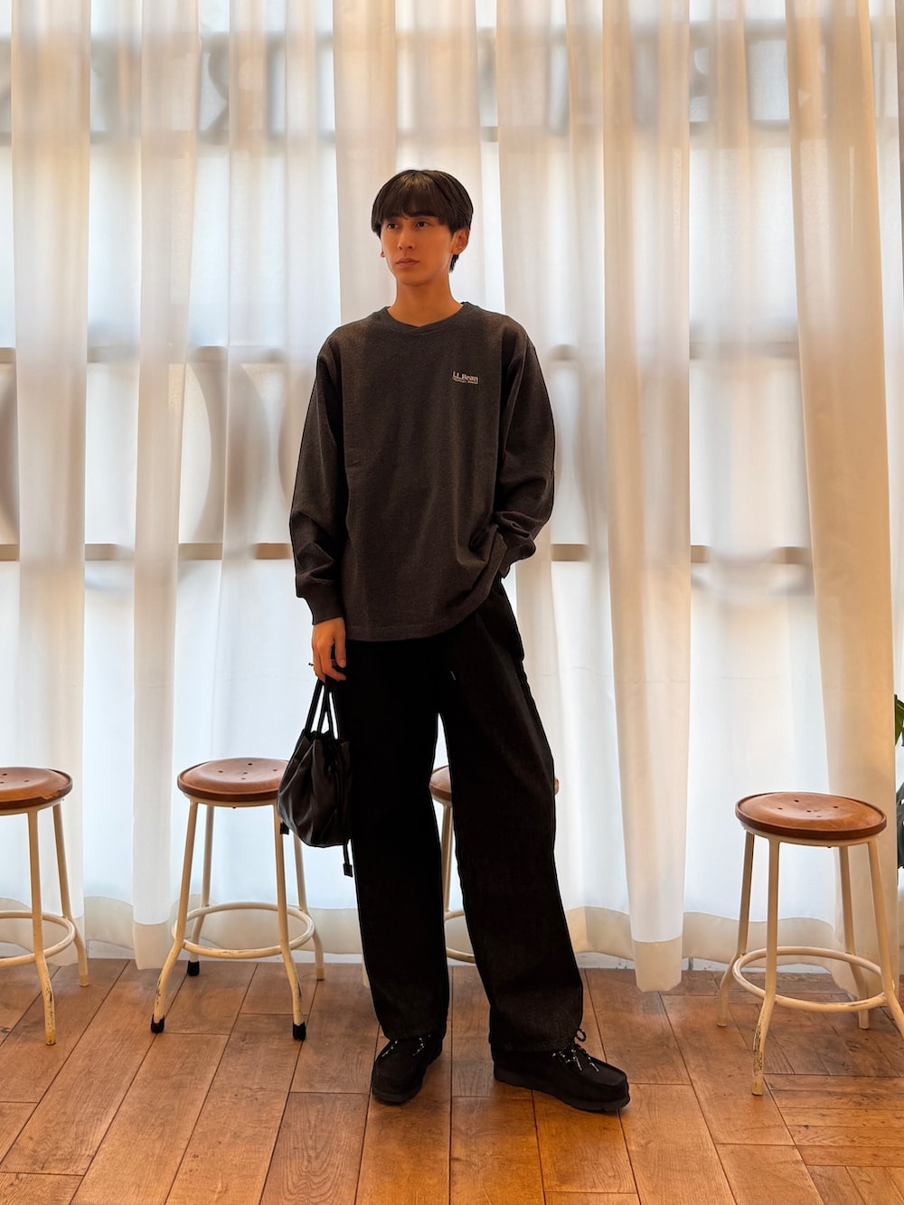 グレー系のTシャツ/カットソー、ブラック系のデニムパンツ、ブラック系のブーツを着用したメンズの秋コーディネートの2枚目の写真