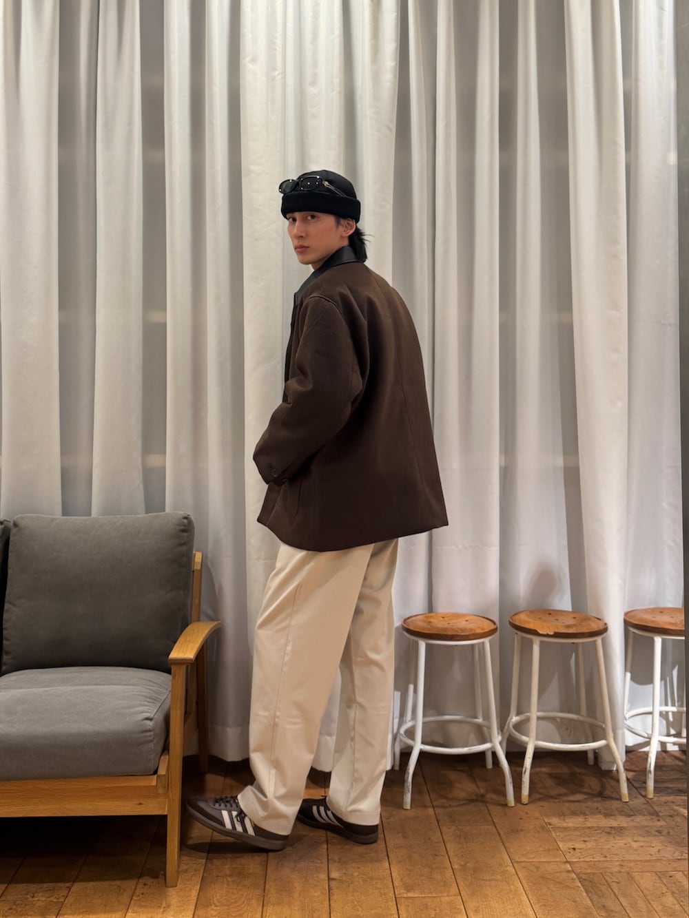 レッド系のニット/セーター、ベージュ系のその他パンツ、ブラウン系のスニーカーを着用したメンズの冬コーディネートの3枚目の写真