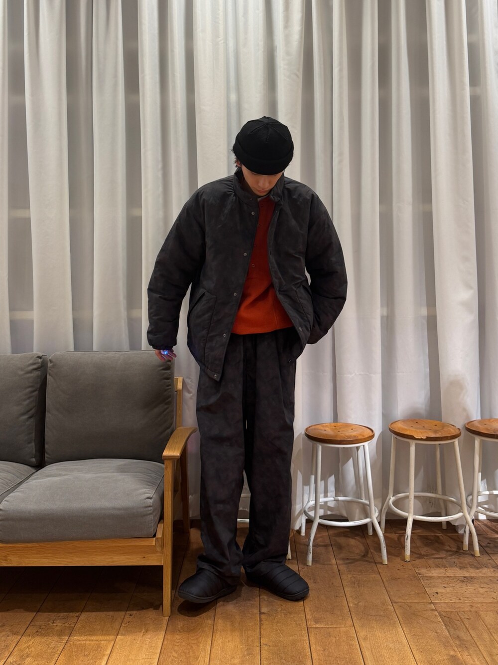 ブラック系のダウンジャケット/コート、オレンジ系のTシャツ/カットソー、ホワイト系のTシャツ/カットソーを着用したメンズの冬コーディネートの2枚目の写真