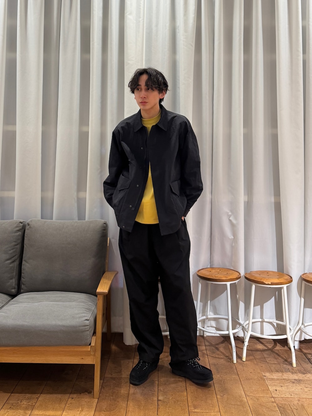 ブラック系のナイロンジャケット、ブルー系のその他パンツ、ブラック系のブーツを着用したメンズの春コーディネートの4枚目の写真