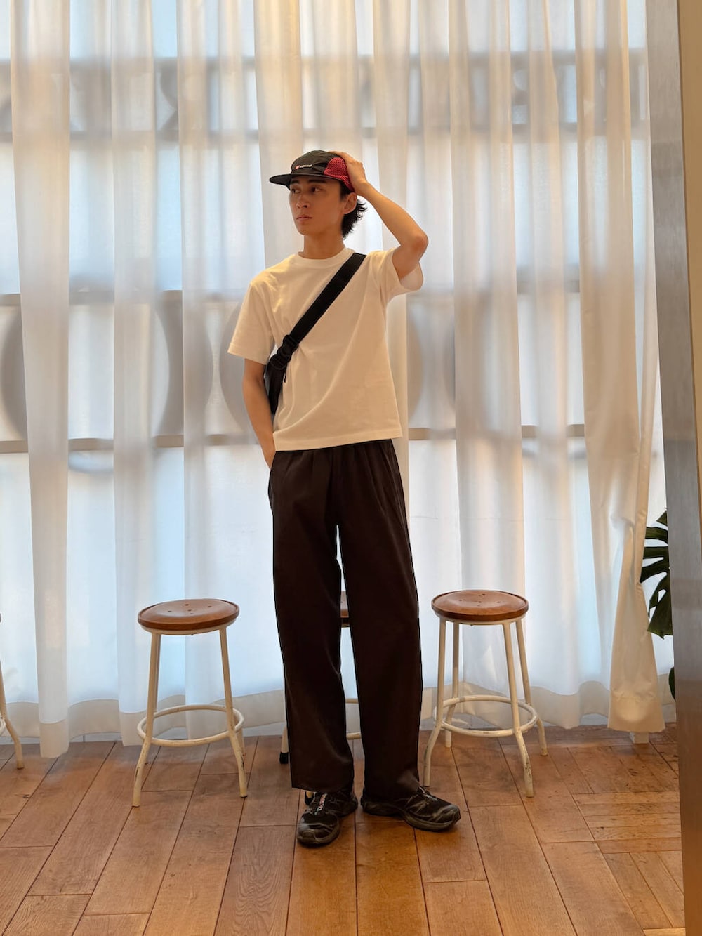 ブラック系のショルダーバッグ、ブラック系のスニーカー、ホワイト系のTシャツ/カットソーを着用したメンズの夏コーディネートの3枚目の写真