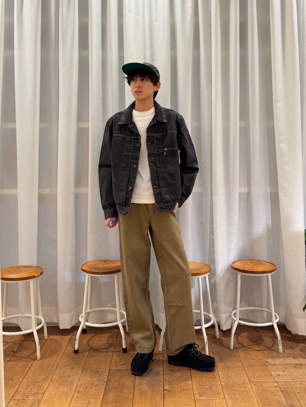 ブラック系のデニムジャケット、ブラック系のブーツ、ホワイト系のTシャツ/カットソーを着用したメンズの夏コーディネートの2枚目の写真