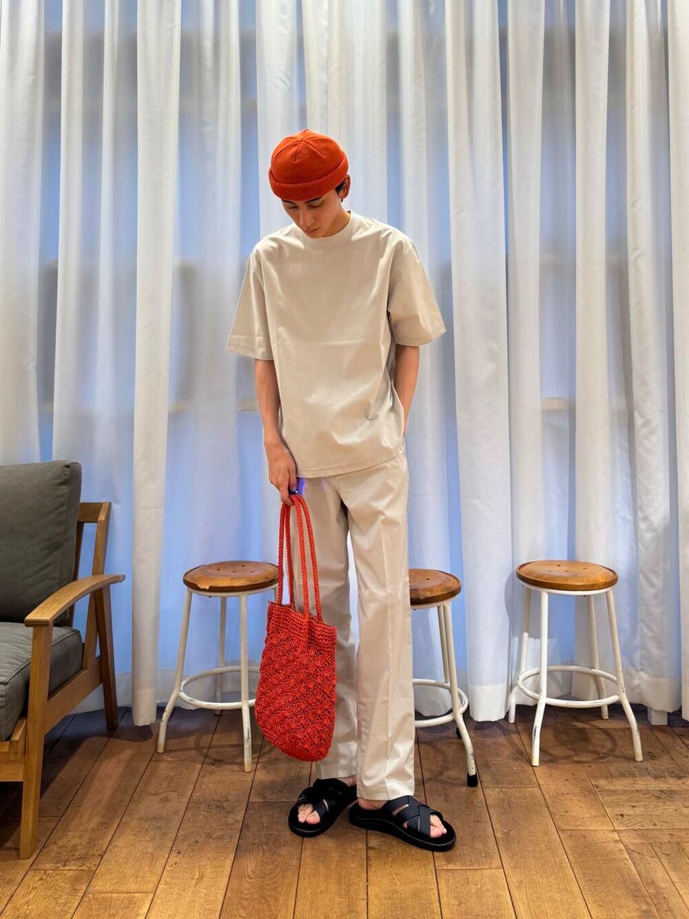 オレンジ系のトートバッグ、グレー系のTシャツ/カットソー、グレー系のその他パンツを着用したメンズの春コーディネートの6枚目の写真