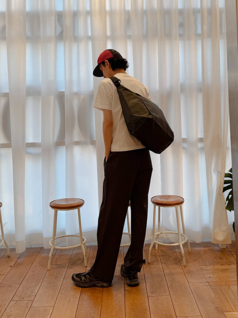 ブラック系のショルダーバッグ、ブラック系のスニーカー、ホワイト系のTシャツ/カットソーを着用したメンズの夏コーディネートの2枚目の写真