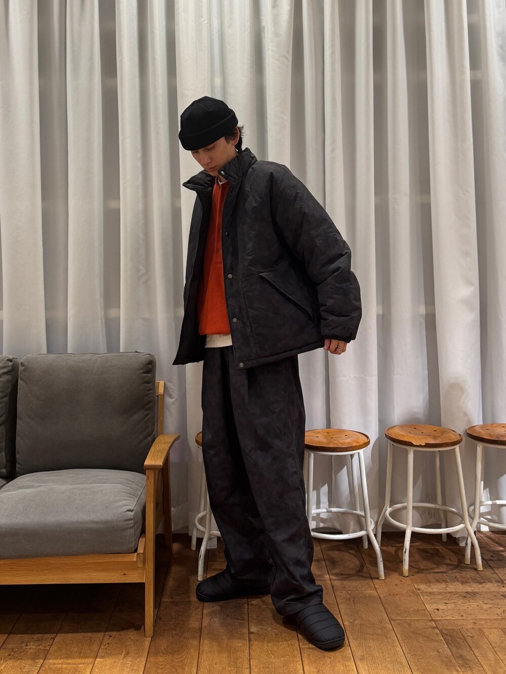 ブラック系のダウンジャケット/コート、オレンジ系のTシャツ/カットソー、ホワイト系のTシャツ/カットソーを着用したメンズの冬コーディネートの6枚目の写真