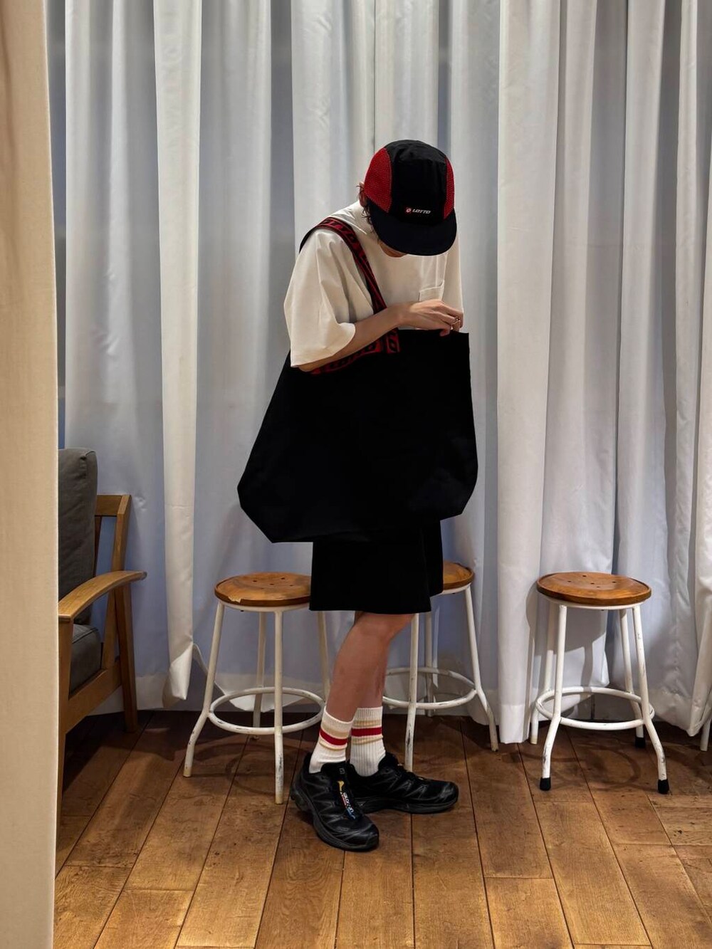 ホワイト系のTシャツ/カットソー、ブラック系のスニーカー、ブラック系のトートバッグを着用したメンズの夏コーディネートの4枚目の写真