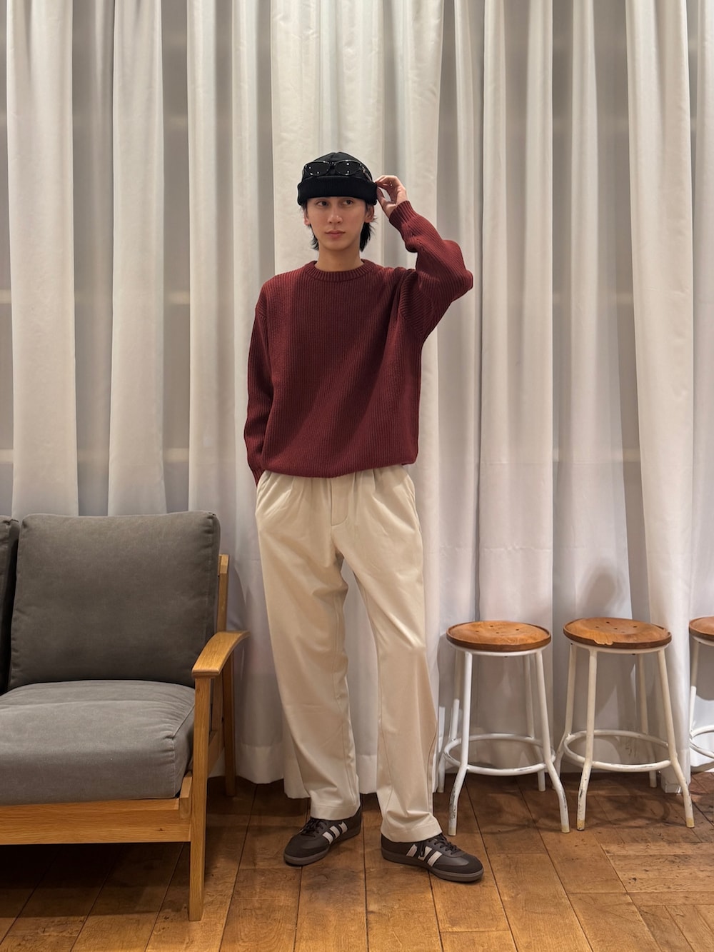 レッド系のニット/セーター、ベージュ系のその他パンツ、ブラウン系のスニーカーを着用したメンズの冬コーディネートの5枚目の写真