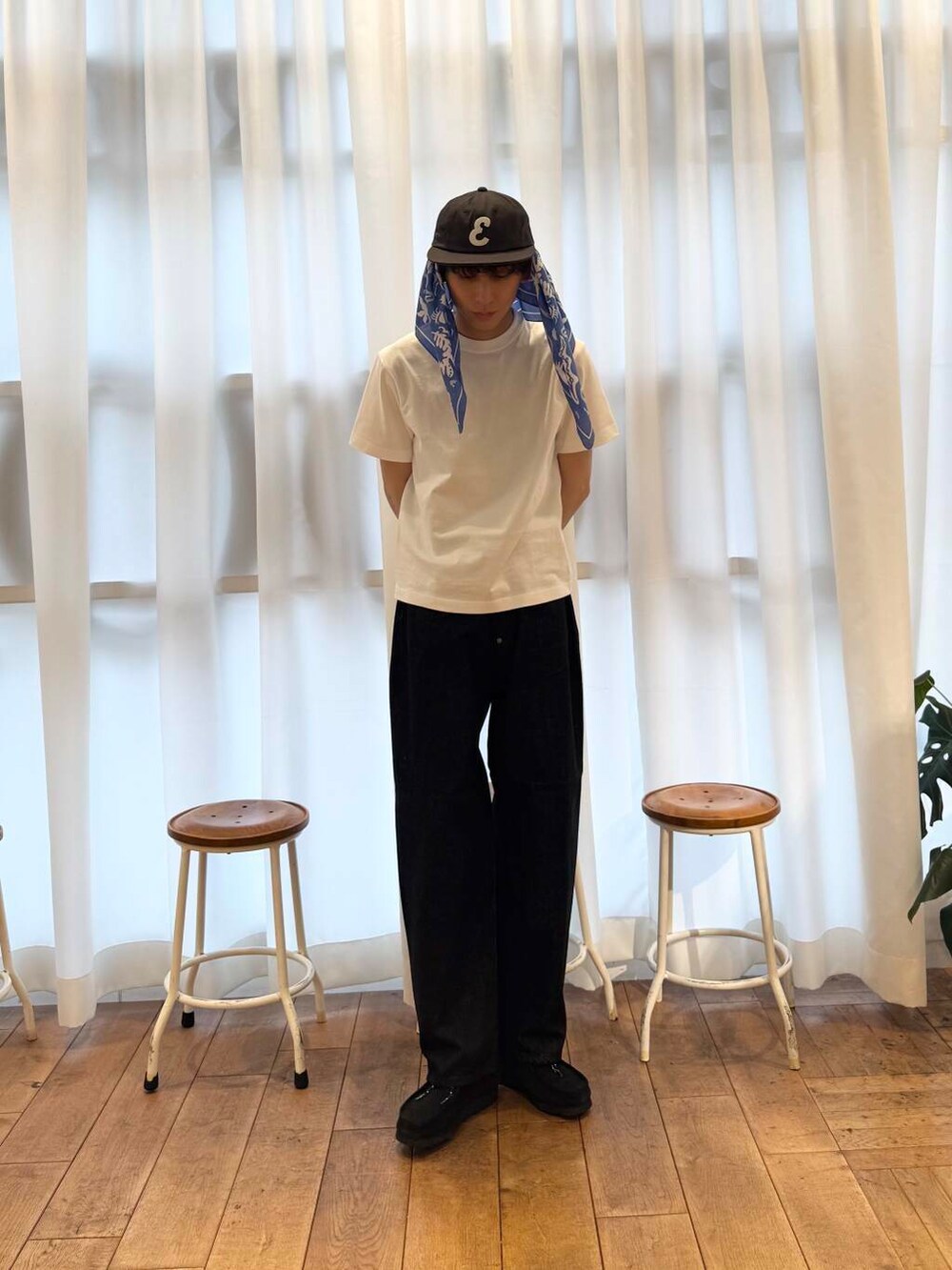 ブラック系のブーツ、ホワイト系のTシャツ/カットソー、ブラック系のデニムパンツを着用したメンズの夏コーディネートの3枚目の写真