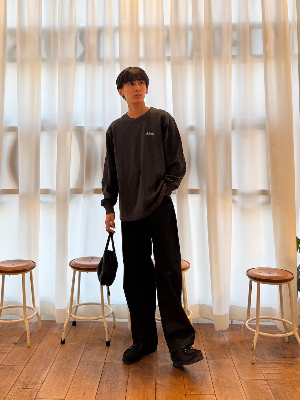 グレー系のTシャツ/カットソー、ブラック系のデニムパンツ、ブラック系のブーツを着用したメンズの秋コーディネートの4枚目の写真