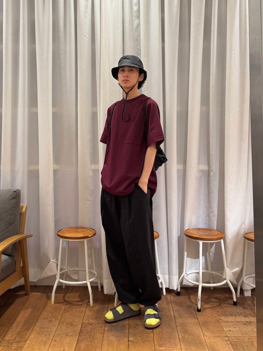 ブラック系のその他パンツ、ブラック系のバックパック/リュック、グレー系のサンダルを着用したメンズの夏コーディネートの5枚目の写真