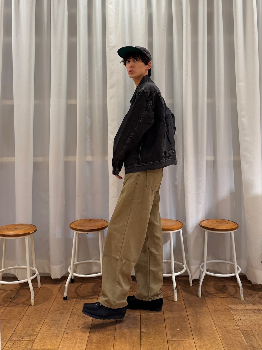 ブラック系のデニムジャケット、ブラック系のブーツ、ホワイト系のTシャツ/カットソーを着用したメンズの夏コーディネートの5枚目の写真