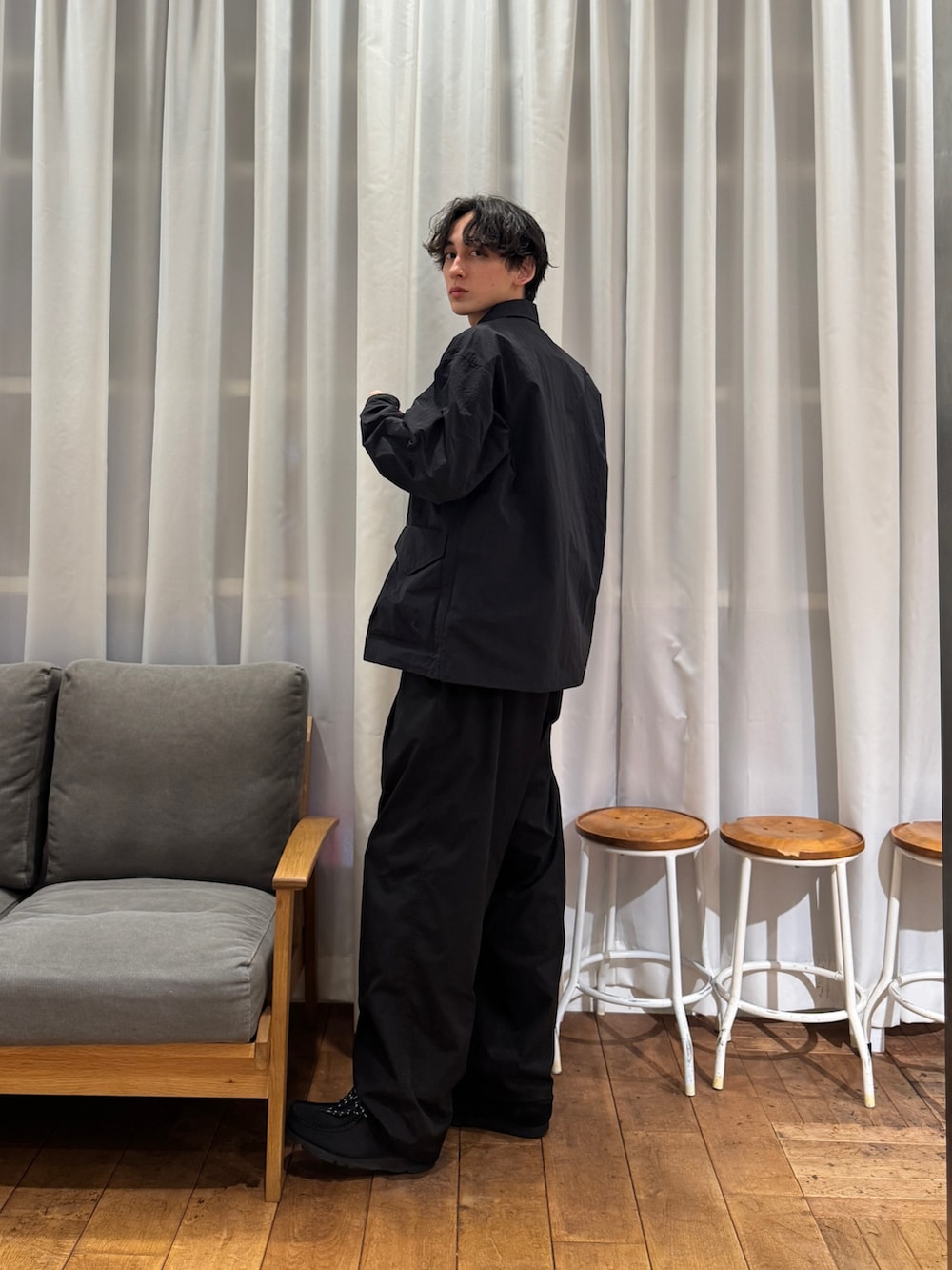 ブラック系のナイロンジャケット、ブルー系のその他パンツ、ブラック系のブーツを着用したメンズの春コーディネートの3枚目の写真