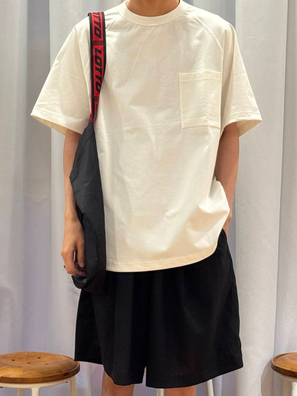 ホワイト系のTシャツ/カットソー、ブラック系のスニーカー、ブラック系のトートバッグを着用したメンズの夏コーディネートの6枚目の写真