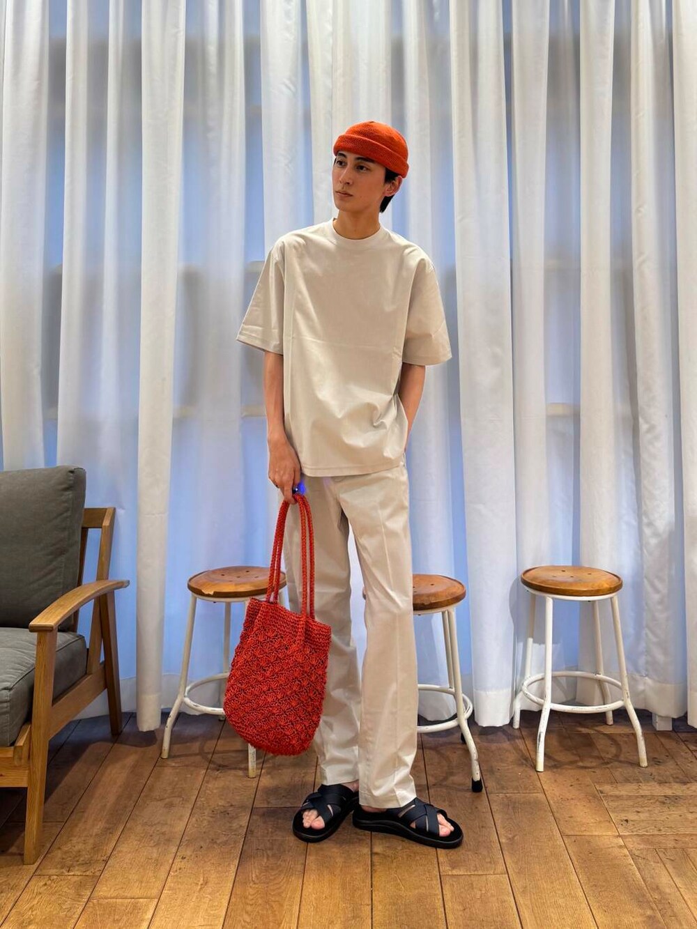 オレンジ系のトートバッグ、グレー系のTシャツ/カットソー、グレー系のその他パンツを着用したメンズの春コーディネートの3枚目の写真