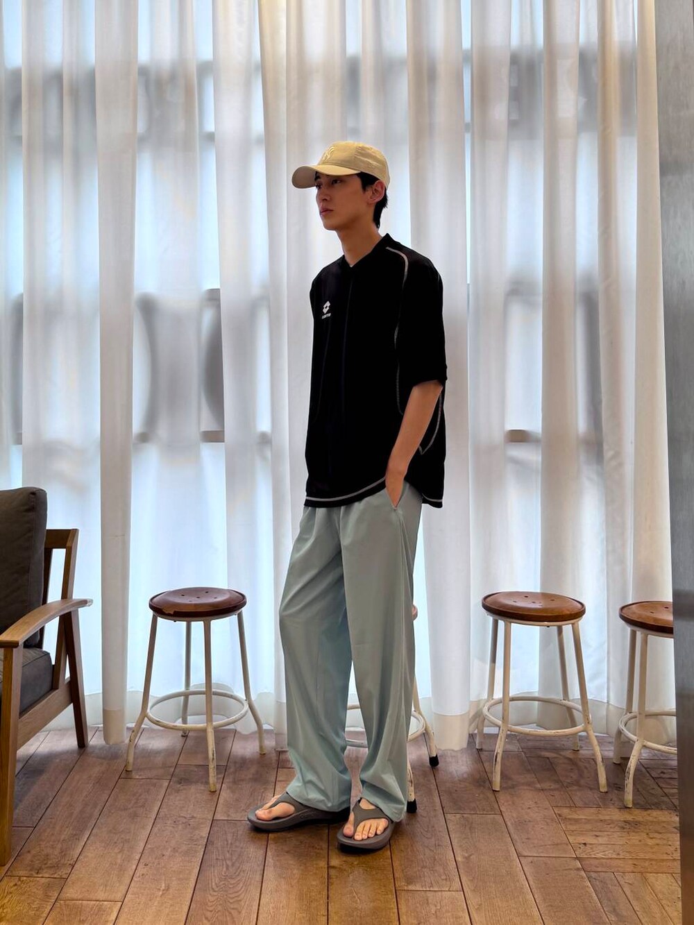 グレー系のサンダル、ブルー系のその他パンツ、ブラック系のTシャツ/カットソーを着用したメンズの春コーディネートの7枚目の写真