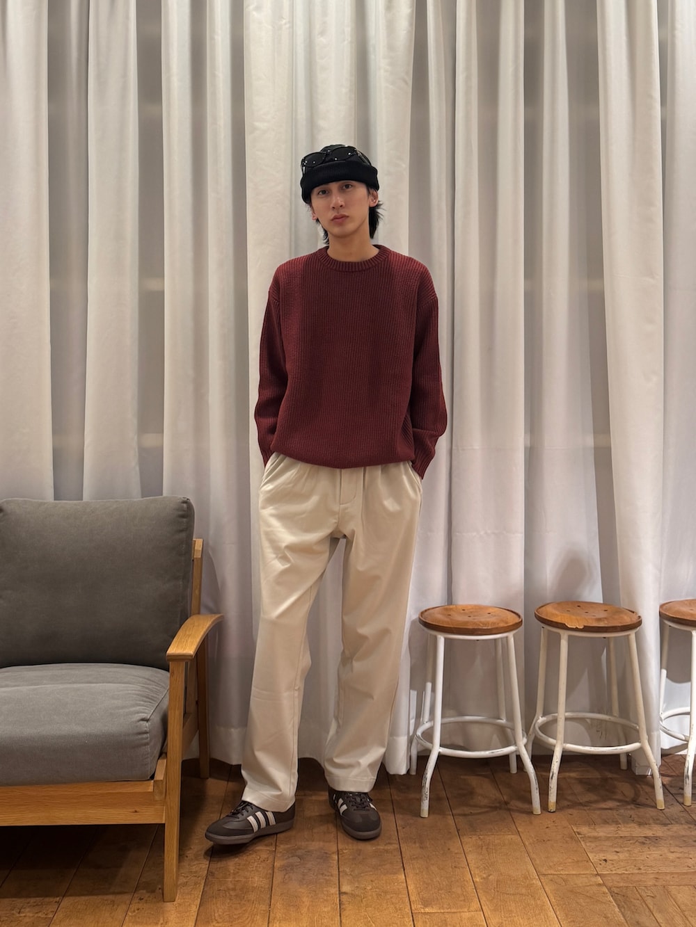 レッド系のニット/セーター、ベージュ系のその他パンツ、ブラウン系のスニーカーを着用したメンズの冬コーディネートの4枚目の写真