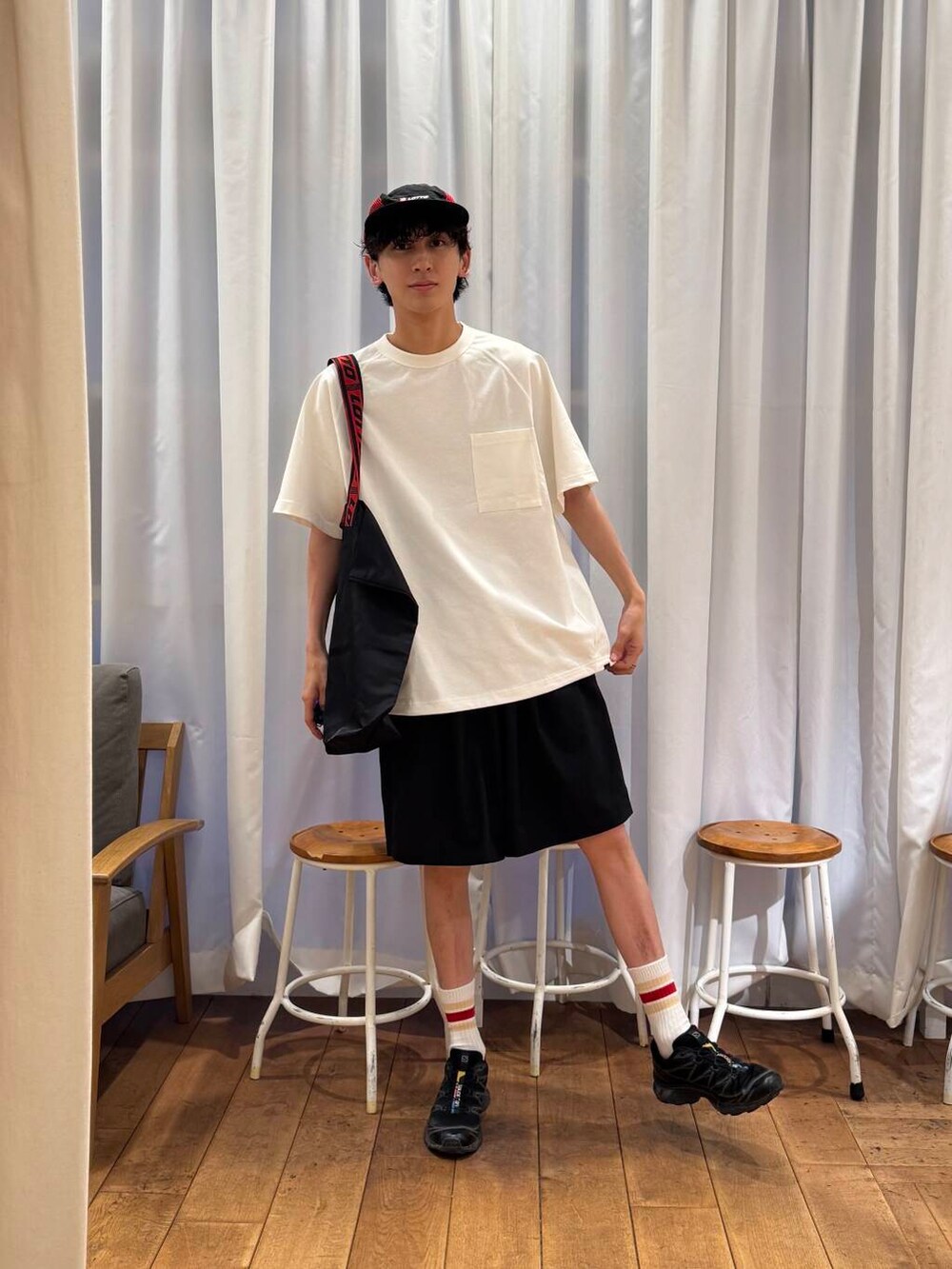 ホワイト系のTシャツ/カットソー、ブラック系のスニーカー、ブラック系のトートバッグを着用したメンズの夏コーディネートの3枚目の写真