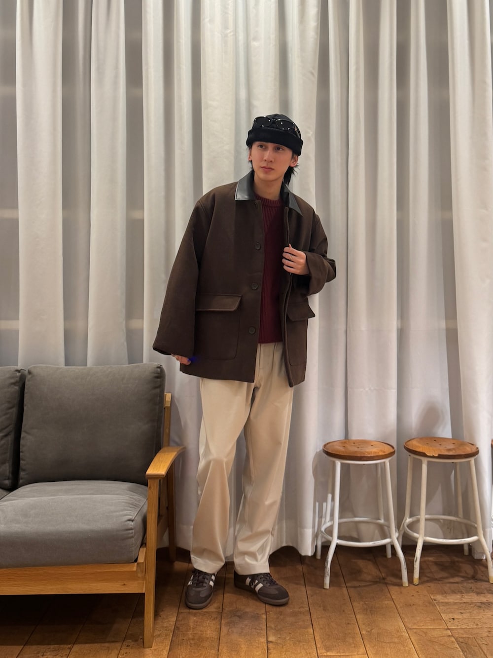 レッド系のニット/セーター、ベージュ系のその他パンツ、ブラウン系のスニーカーを着用したメンズの冬コーディネートの2枚目の写真