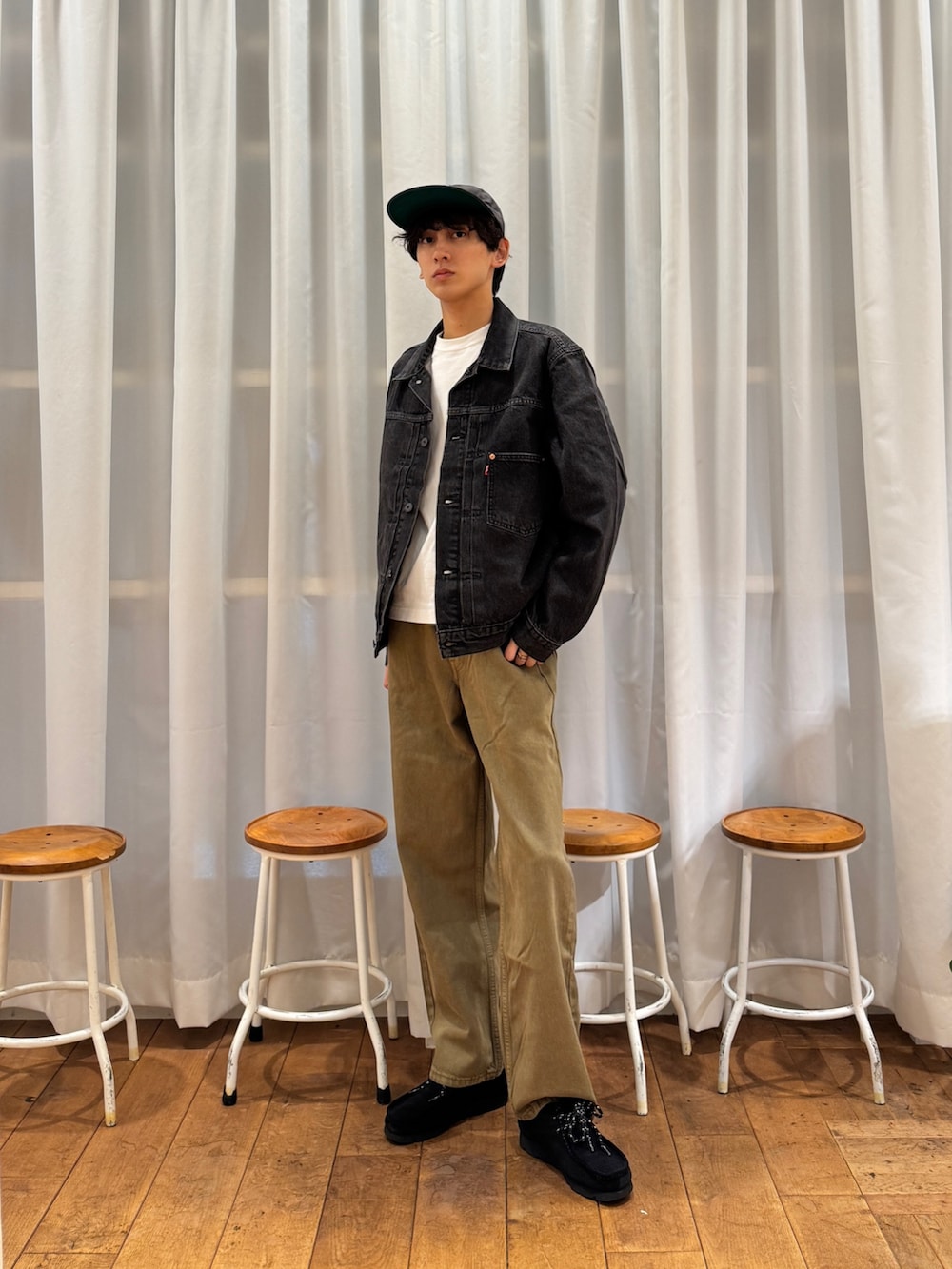 ブラック系のデニムジャケット、ブラック系のブーツ、ホワイト系のTシャツ/カットソーを着用したメンズの夏コーディネートの6枚目の写真