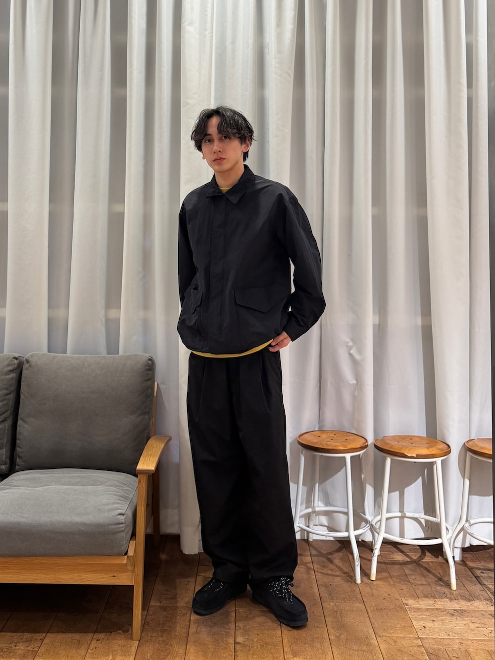 ブラック系のナイロンジャケット、ブルー系のその他パンツ、ブラック系のブーツを着用したメンズの春コーディネートの2枚目の写真