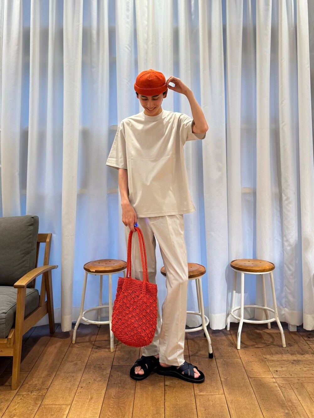 オレンジ系のトートバッグ、グレー系のTシャツ/カットソー、グレー系のその他パンツを着用したメンズの春コーディネートの2枚目の写真