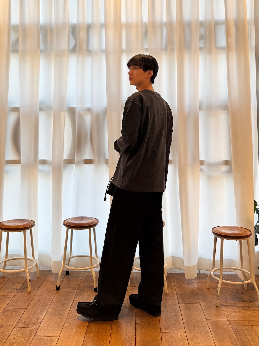 グレー系のTシャツ/カットソー、ブラック系のデニムパンツ、ブラック系のブーツを着用したメンズの秋コーディネートの3枚目の写真