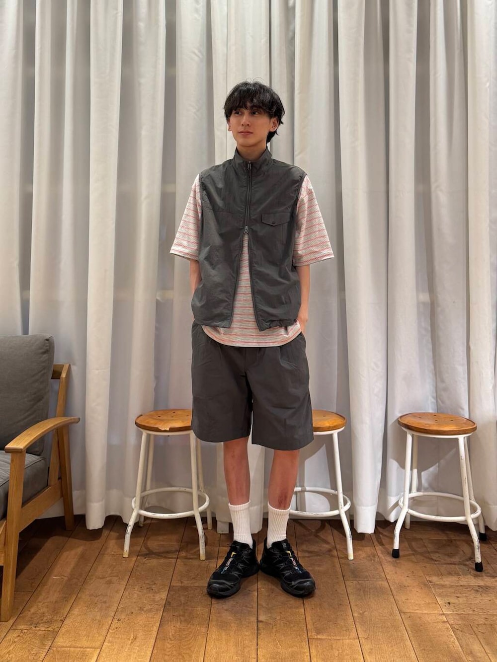 グレー系のベスト、グレー系のその他パンツ、ブラック系のスニーカーを着用したメンズの春コーディネートの6枚目の写真